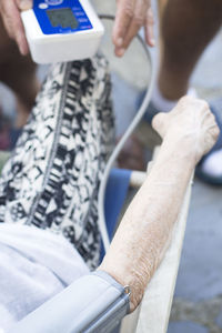 Midsection of doctor examining patient blood pressure in hospital