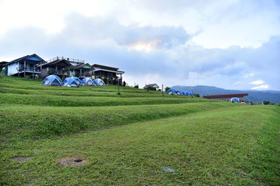 Houses on field against sky