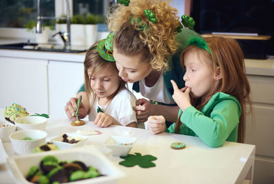 High angle view of mother with daughter making cookies on table