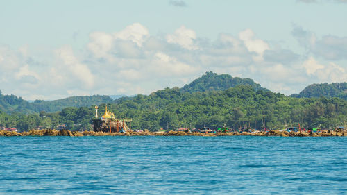 Scenic view of sea by buildings against sky