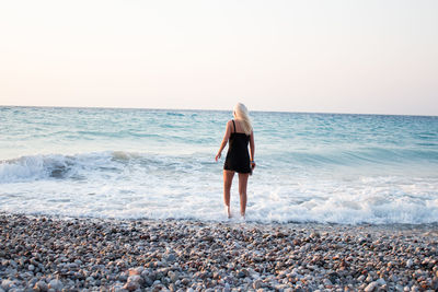 Full length of woman on beach against clear sky