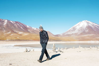 Bolivia, eduardo avaroa andean fauna national reserve, man wearing chullo, walking at laguna verde