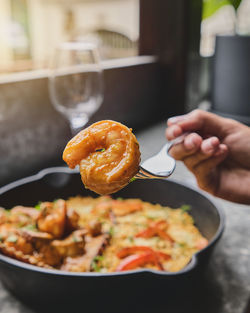 Woman enjoy peruvian food rice with seafood. arroz con mariscos, food served in pan, selective focus