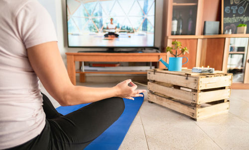 Midsection of woman sitting on table