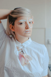 Close-up portrait of woman with painted face at home