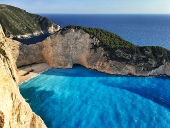 Rock formation against sea in sunny day