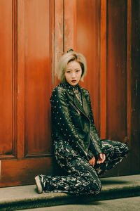 Portrait of girl sitting against door