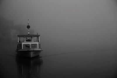 Boat moving in lake during foggy weather