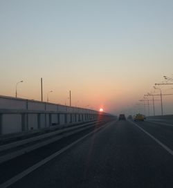 Road against clear sky during sunset