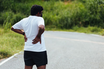 Rear view of man standing on road