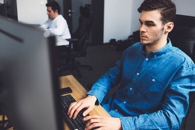 Young man using laptop at office