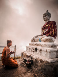 Statue of buddha sitting against sky