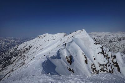 Scenic view of snowcapped mountains against clear blue sky