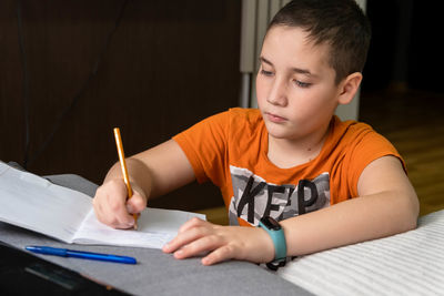 Boy drawing on book at home