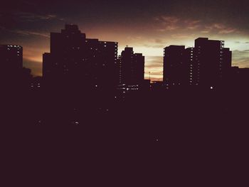 Silhouette of buildings against sky at dusk