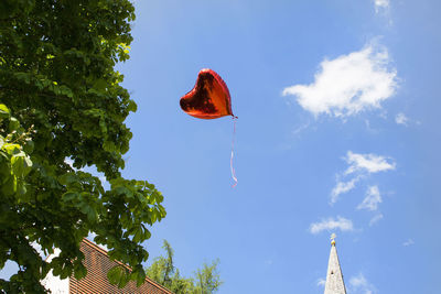 Low angle view of heart shape balloon in sky