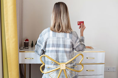 Rear view of woman showing credit card