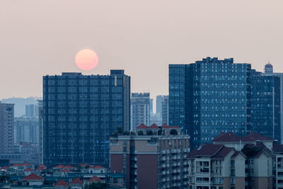 Buildings in city against clear sky