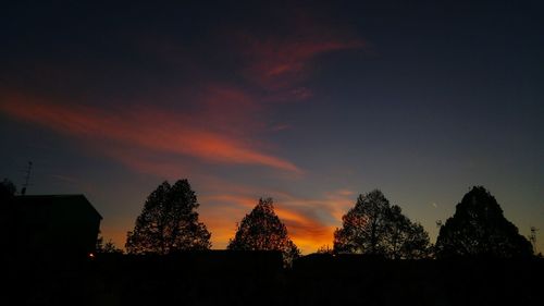 Low angle view of silhouette trees against sky at sunset