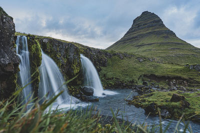 Scenic view of waterfall against sky