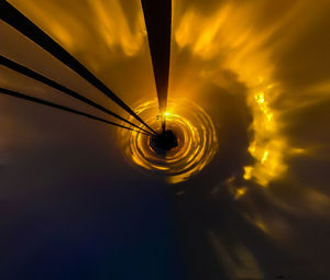 Low angle view of illuminated light against sky at sunset