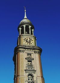 Low angle view of clock tower against blue sky