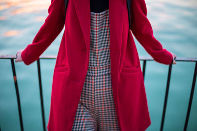 Midsection of woman standing against lake