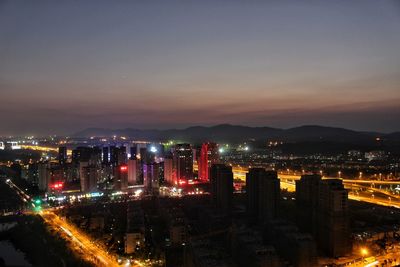 High angle view of illuminated cityscape against sky at night