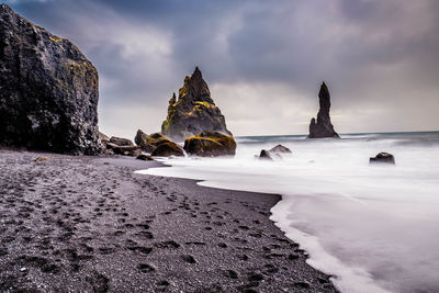 Rocks on beach against sky