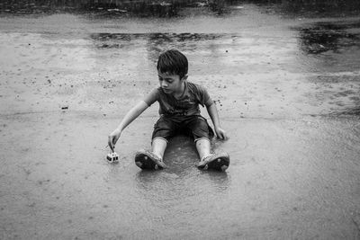 Full length of boy playing in puddle during rain