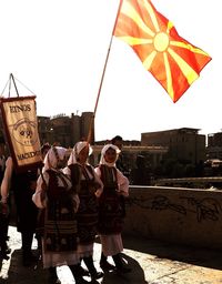People standing at beach against clear sky