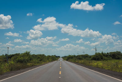 Road amidst trees against sky