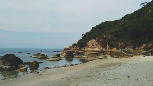 Rocks on beach against sky