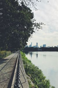 Scenic view of river by city against sky