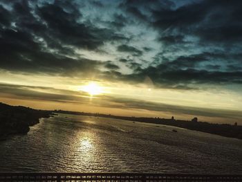 Scenic view of sea against cloudy sky at sunset