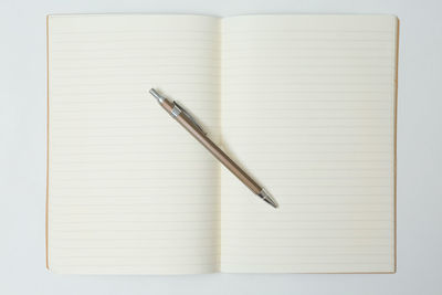 High angle view of pen on book against white background