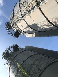 Low angle view of storage tanks against sky