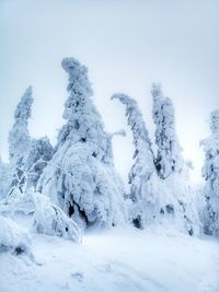 Snow covered land against clear sky