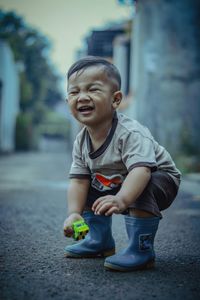 Portrait of boy standing on footpath