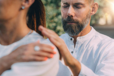 Reiki lesson. reiki instructor with hands over shoulders of the course attendee