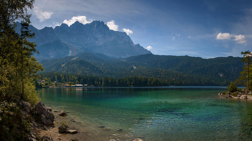 Scenic view of lake by mountains against sky