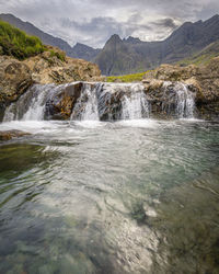 Scenic view of waterfall against sky