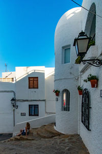 Woman sitting against buildings