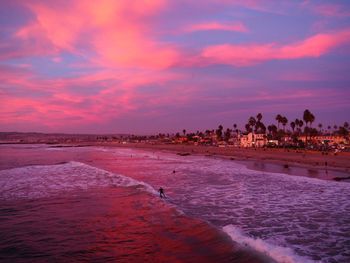 Scenic view of beach against sky at sunset