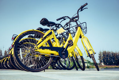 Bicycles parked on road against clear blue sky
