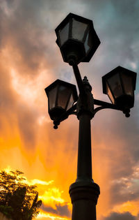 Low angle view of street light against orange sky