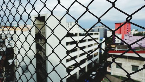 Close-up of chainlink fence against building