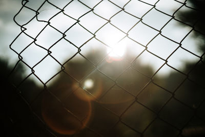 Close-up of chainlink fence against sky