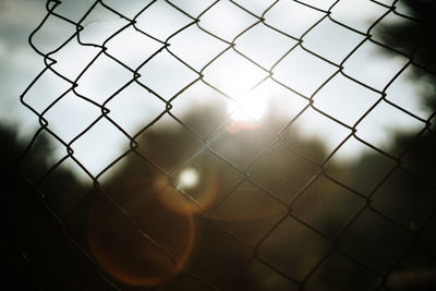 Close-up of chainlink fence against sky