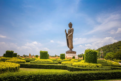 Statue on field against cloudy sky
